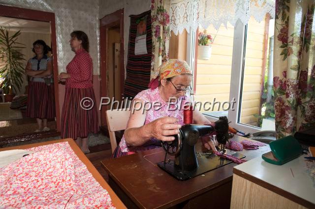 estonie 25.JPG - Estonie, comté de Pärnu, île de Kihnu, vieille femme confectionnant un vêtement traditionnel à la machine à coudre